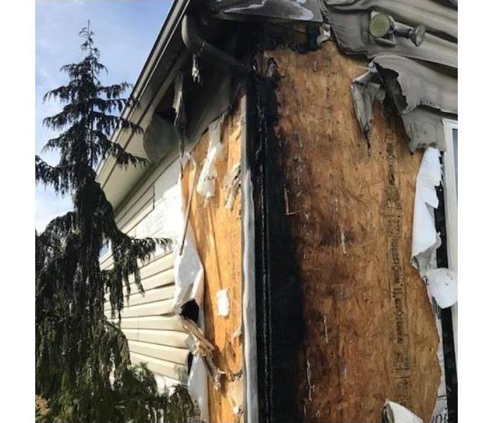 section of siding of a house singed and damaged. 