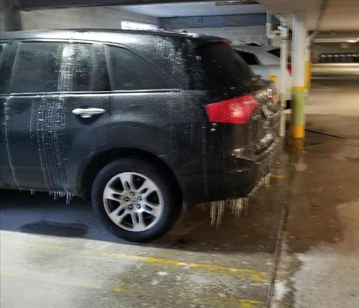 Icicles hanging from vehicle in a parking garage.  